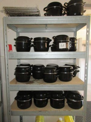 de nombreuses casseroles et poêles sur les étagères de la cuisine