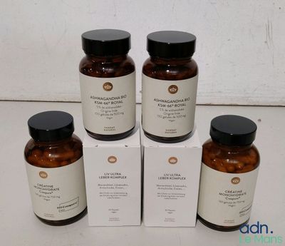 quatre flacons de produits de soin posés sur une table