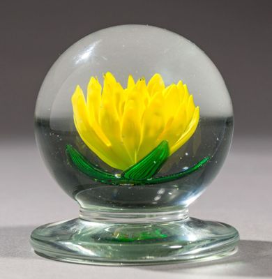 une boule de verre contenant une fleur jaune