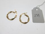 une paire de boucles d'oreilles créoles en or avec une étiquette de prix