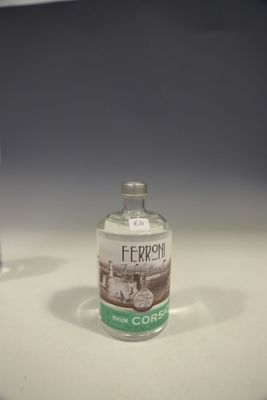 une bouteille d'alcool posée sur un comptoir à côté d'un verre d'eau