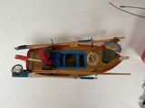 a small wooden boat with a paddle and some fishing gear