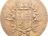 a close up of a gold medal with a coat of arms on it