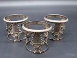 three silver vases sitting on top of a table next to each other