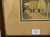 painting of an old building in a wooden frame on a wall