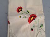 un gros plan sur un morceau de tissu orné de fleurs rouges