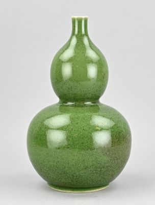un vase vert orné d'un motif représentant deux calebasses
