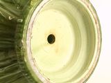 a green vase that has a hole in it