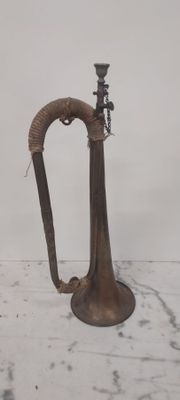 un petit vase en métal muni d'une anse, posé sur une table