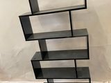 a black bookcase with a glass shelf on top of it