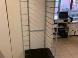 a metal cart with a shelf in the middle of a room