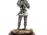 statue d'un chevalier en armure complète tenant une épée, posée sur un socle en bois