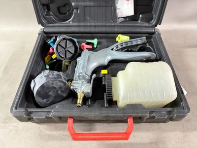 une trousse à outils dans un coffret en plastique posée sur une table