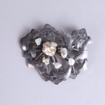 a picture of a brooch with pearls on it