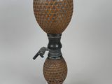 a small vase with a handle on a white pedestal
