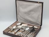 silverware in a wooden box on a white surface