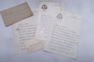 trois vieilles lettres et un bout de papier posés sur une surface blanche