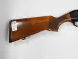 a shotgun mounted on a wall with a tag on it