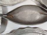 several spoons and pans are lined up on a table