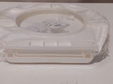 a plastic ashtray on a white table with a sticker