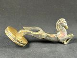 an antique brass figurine of a horse with a bell