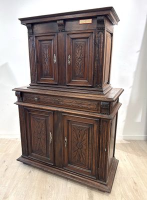 une vieille armoire en bois posée sur un sol en bois dur