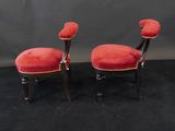 two red chairs with black legs and a red cushion