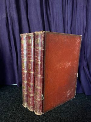 un vieux livre posé sur une table noire, à côté d'un rideau violet