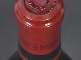 a close up of a bottle of wine with a red cap