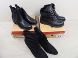 deux paires de bottes noires posées sur une boîte