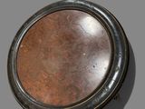 a small round metal object on a gray surface