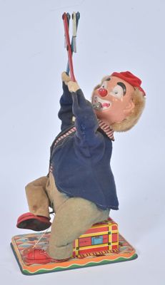 a small figurine of a clown holding a tennis racquet