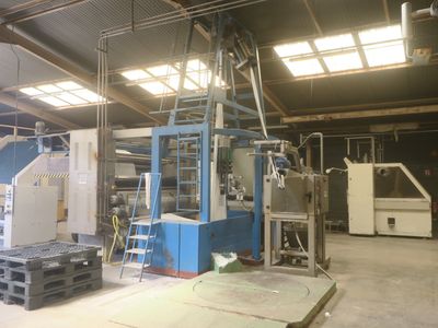 a picture of a factory with a machine and some pallets