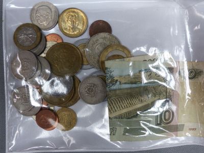 beaucoup de pièces de monnaie dans un sac en plastique posé sur la table