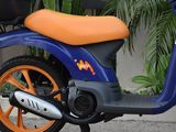 a blue and orange scooter parked in front of a building