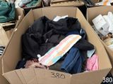 a cardboard box filled with clothes and other items