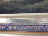 a picture of a painting on a shelf with a plaque on it