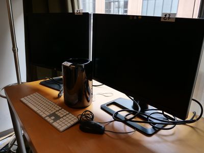 deux écrans et un clavier posés sur un bureau devant une fenêtre
