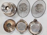 four silverplated dishes and a basket on a white table