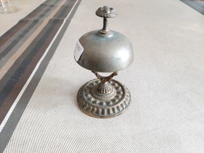 un petit objet métallique posé sur une table recouverte d'une nappe rayée