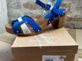 blue and white high heeled sandals in a box on a table