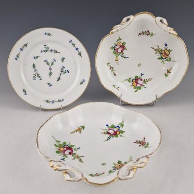 two plates with floral designs and gold trims on them