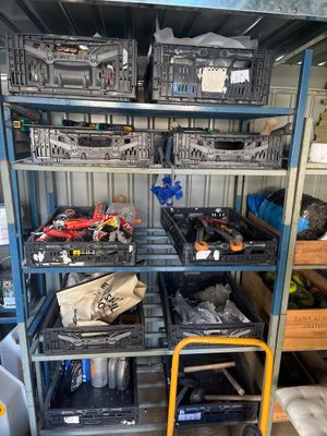 many different types of tools on the shelves in the garage