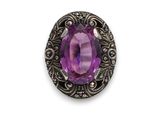 un gros plan sur une pierre violette sertie dans un monture en argent