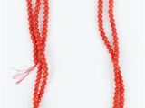 un collier de perles rouges muni d'un fermoir en argent, sur fond blanc