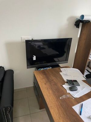 a desk with a computer and a chair in a room