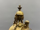 a gold clock sitting on top of a table