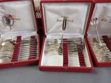 three red boxes with silver spoons and spoons in them