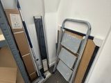 a pile of boxes and a ladder in the corner of a room