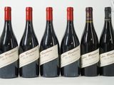 six bouteilles de vin rouge alignées sur une table
